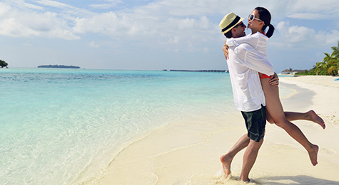 A happy couple hugging on a beach.